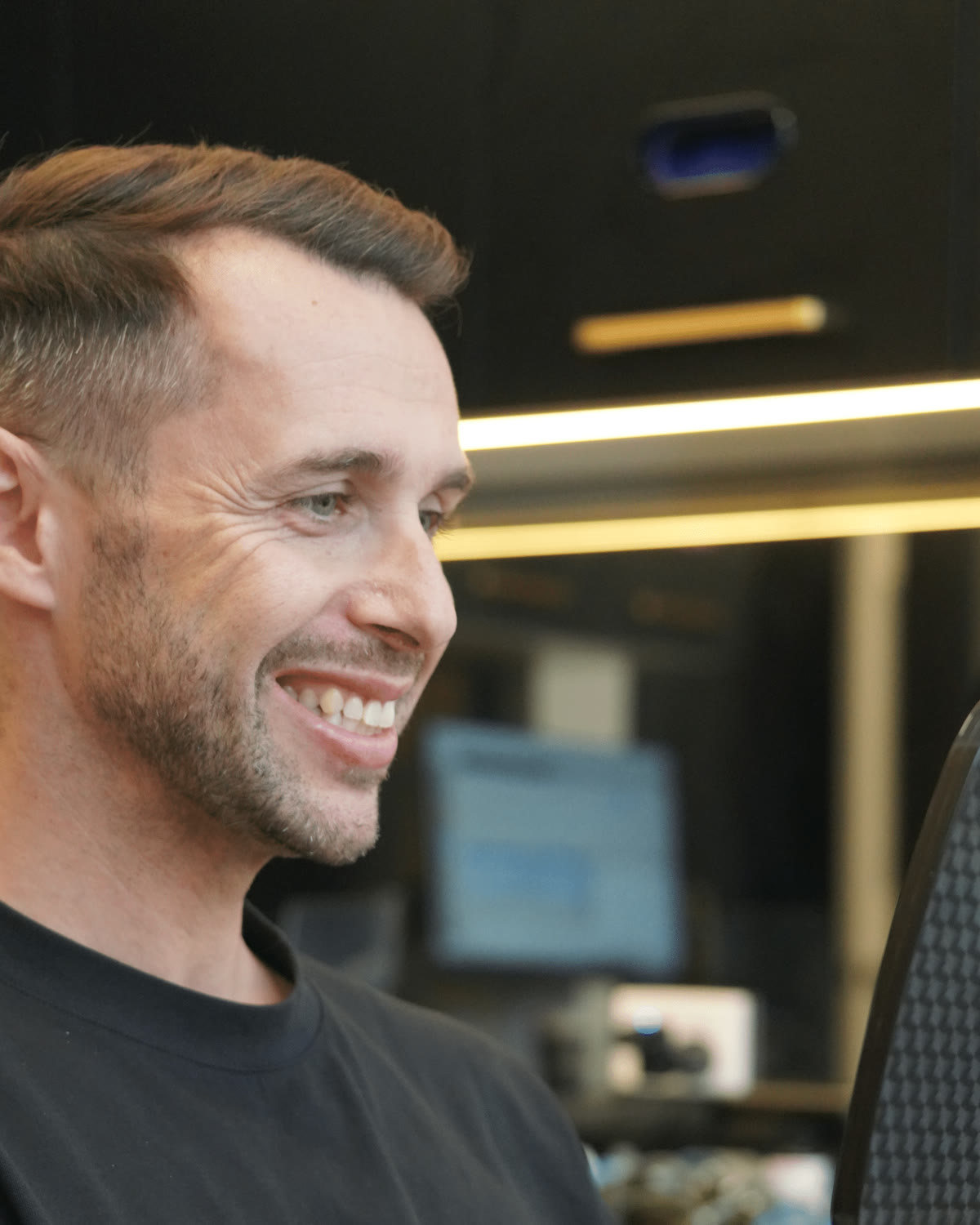 A patient smiling as he checks his teeth in a Lumina Dental hand mirror