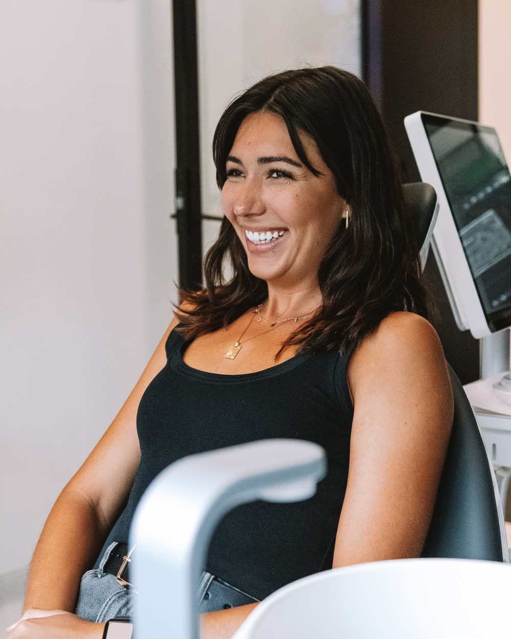 A relaxed patient laughing in the chair at Lumina Dental