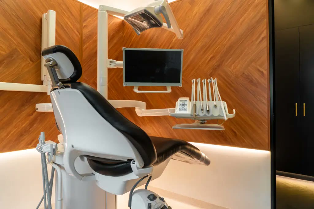 Treatment room with herringbone timber walls and a white dental chair